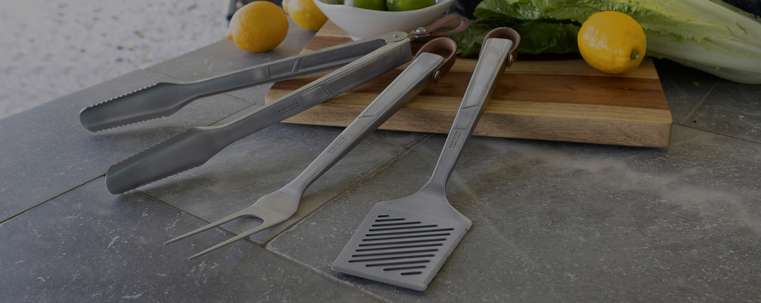 Quantum steel spatula fork and tongs on chopping board